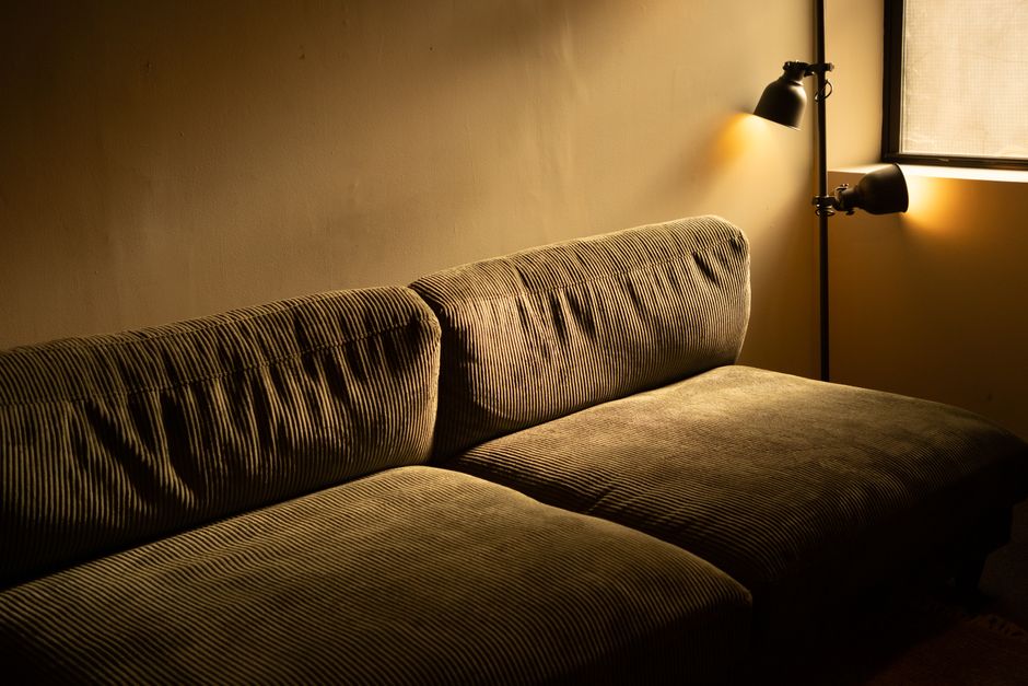 Warm interior shot of a cozy sofa with ambient lighting in a quiet living room.